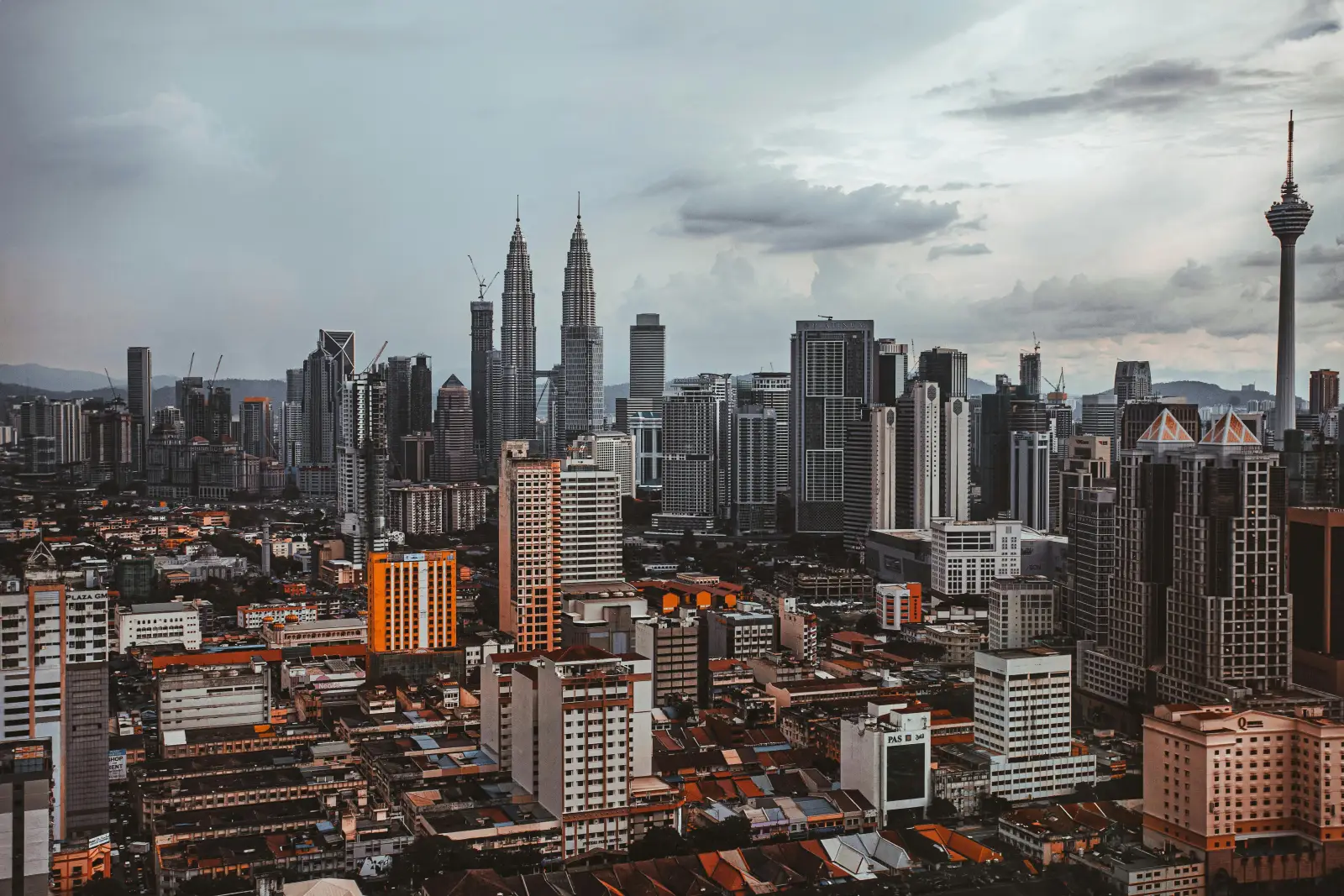Aerial view of Kuala Lumpur skyline featuring Petronas Twin Towers and KL Tower